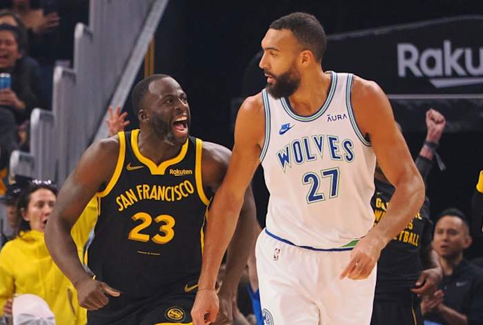 Nov 12, 2023; San Francisco, California, USA; Golden State Warriors forward Draymond Green (23) celebrates behind Minnesota Timberwolves center Rudy Gobert (27) after scoring a three point basket during the first quarter at Chase Center.